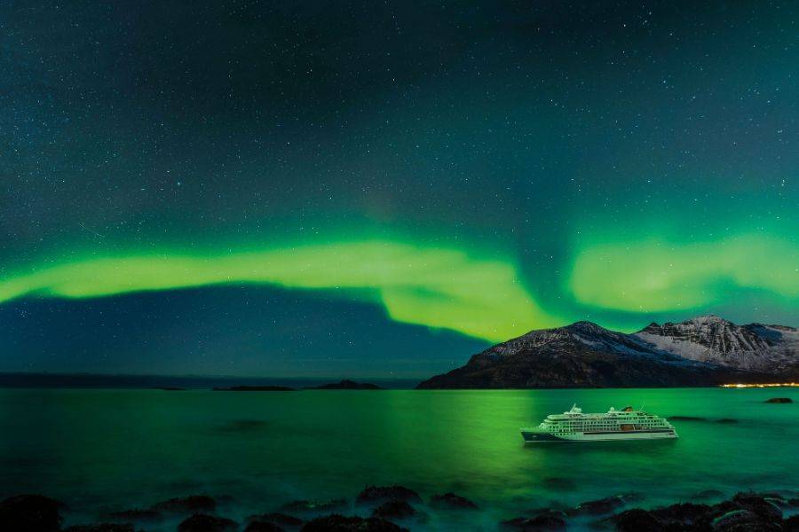 Kreuzfahrtschiff unter Nordlichtern in Norwegen