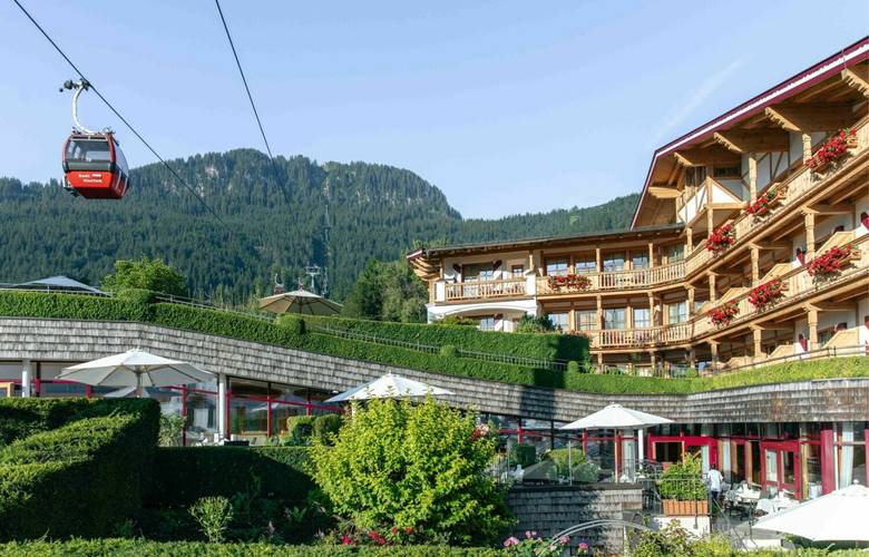 Außenansicht des Hotel Kaiserhof Kitzbühel mit Blick auf die Kitzbüheler Alpen und die Hahnenkamm-Bergbahn