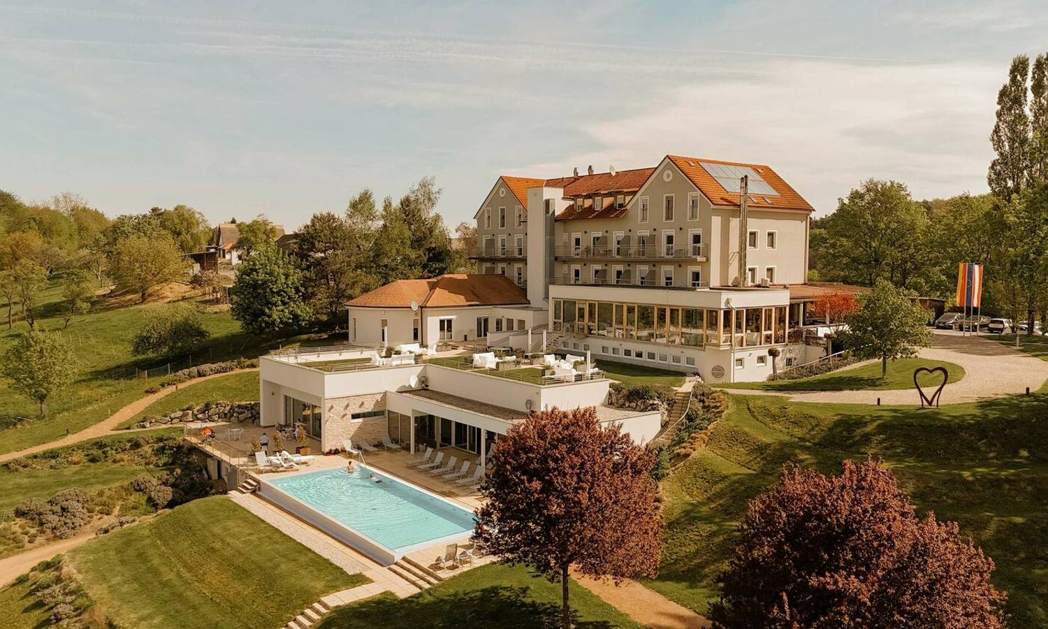 Seminarhotel Das Eisenberg mit Naturumgebung, Gartenlandschaft,  Panorama Außenpool und Blick über die sanften Hügel des Burgenlands
