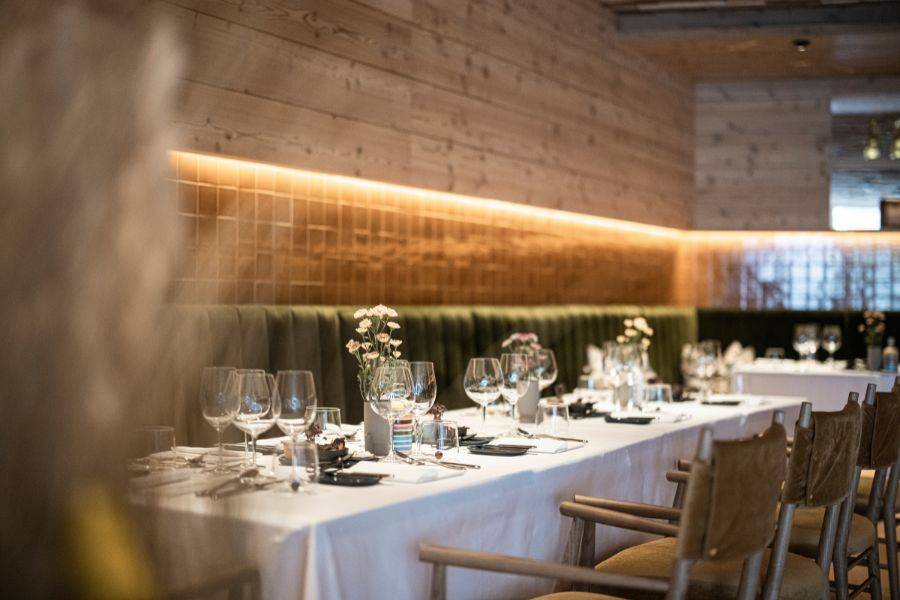 Festlich gedeckter Tisch in einem modernen Restaurant mit Holzverkleidung, stimmungsvollem Licht und stilvollen Dekorationen.