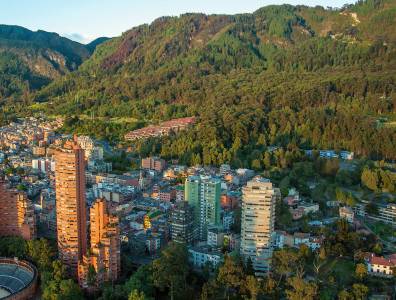 Stadtansicht von Bogotá, Kolumbien, mit Hochhäusern vor grünen Hügeln.