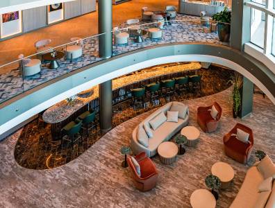 Stilvolle Lobby mit Bar und modernen Sitzbereichen auf einem Kreuzfahrtschiff