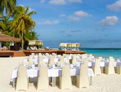 Festlich gedeckte Tische für eine Hochzeitsrezeption am Strand.