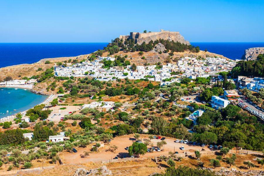 Weißes Dorf Lindos mit Akropolis auf dem Hügel und Blick auf das Meer auf Rhodos, Griechenland