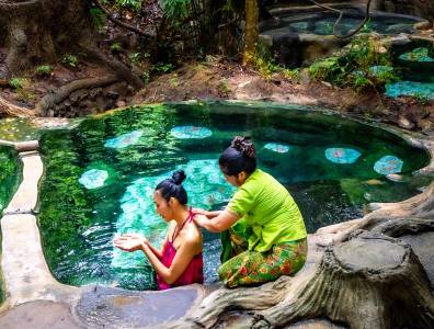 Traditionelle Healing Wellness Anwendung in Thailand mit Kräuterbad im natürlichen Thermalpool