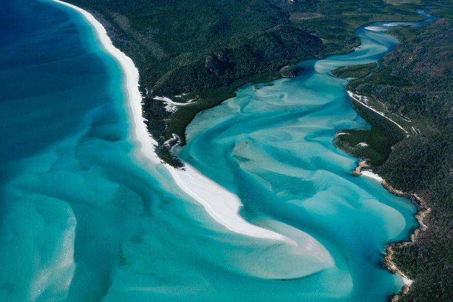 Luftaufnahme von Whitehaven Beach mit türkisblauen Wasserarmen und weißem Sand auf den Whitsunday Islands