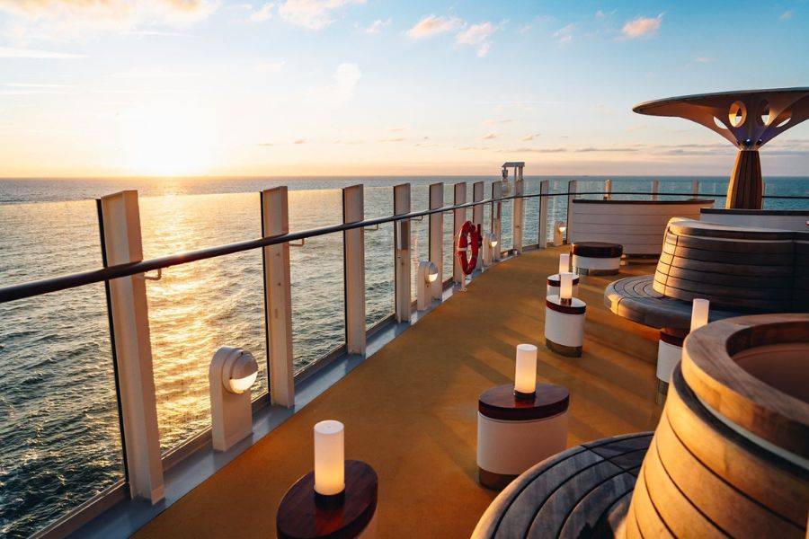© AIDA Sonnenuntergang auf dem Außendeck der AIDACosma mit moderner Sitzlounge und Meerblick