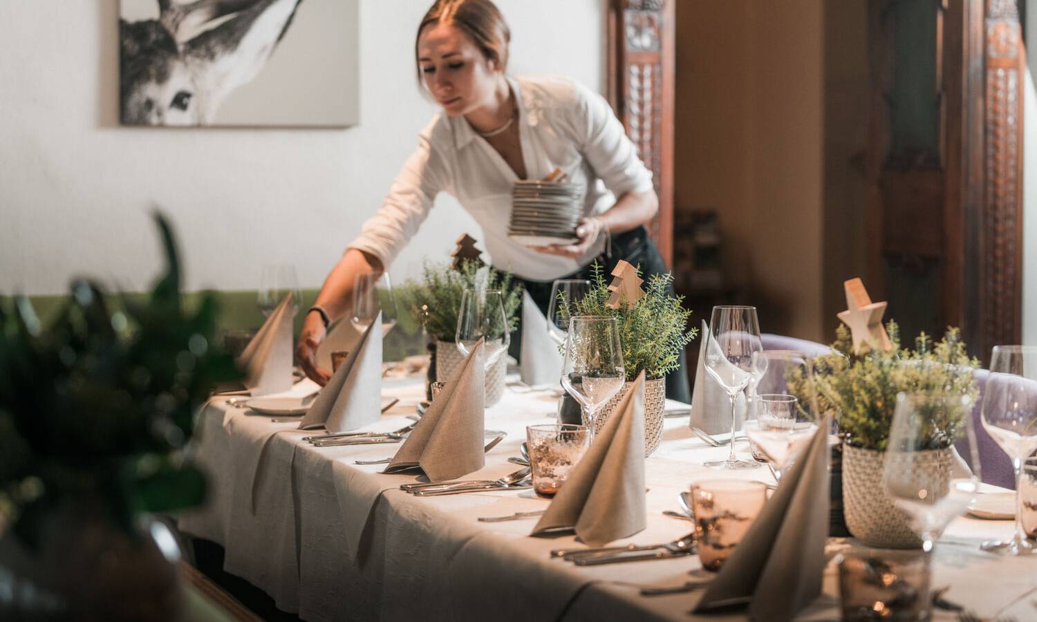 Seeterrasse am Wolfgangsee bei Paul der Wirt mit Gästen, Barbereich, Kirche St. Wolfgang und Sonnenuntergang über dem See