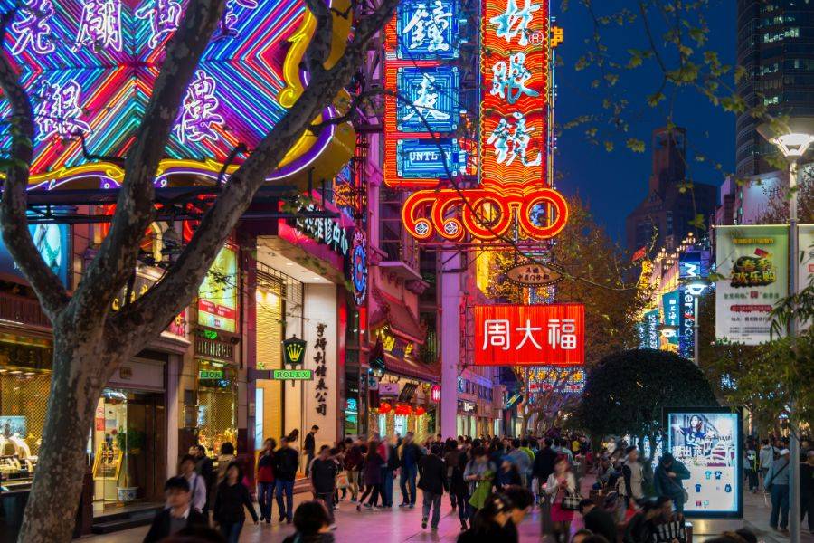 Belebte Einkaufsstraße Nanjing Road in Shanghai mit bunten Neonreklamen