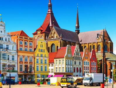 Typische, bunte Häuser umrunden einen historischen Marktplatz.