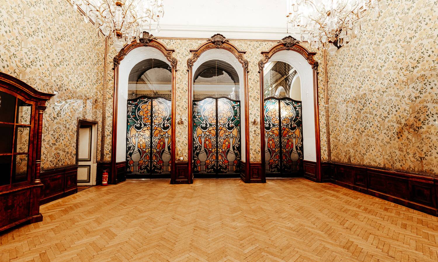 Großer Bankettbereich im Palais Auersperg mit gedeckten Tischen für Dinner‑Events und Feiern und großem Kristallkronleuchter