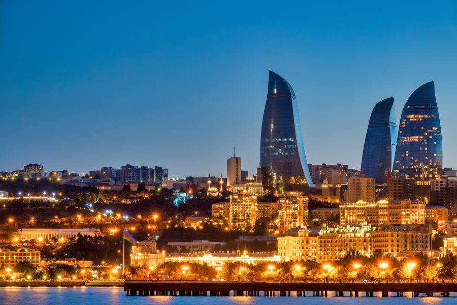 Das Bild zeigt die eindrucksvolle Skyline von Baku, der Hauptstadt Aserbaidschans, bei Nacht