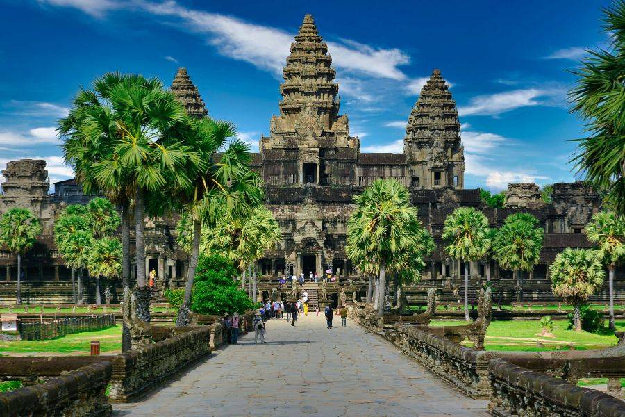© Unsplash Eingangsbereich des historischen Tempelkomplexes Angkor Wat in Kambodscha mit Palmen